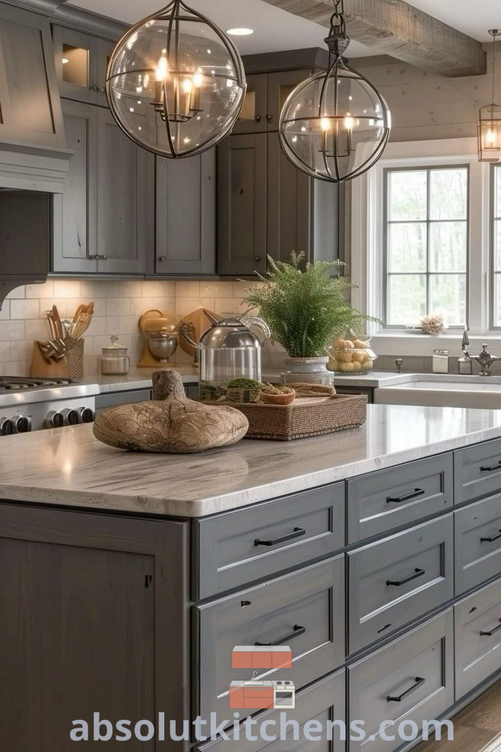 A large modern kitchen with gray cabinets and marble countertops, showcasing two chandeliers hanging from the ceiling, exemplifying kitchen island decor ideas. This space offers inspiring design tips for cozy aesthetics and functional decor for both house or apartment settings. Explore more at absolutkitchens.com.