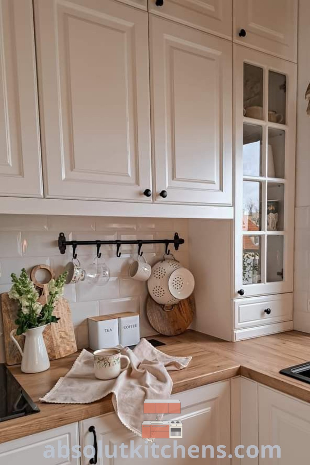 A bright kitchen with white cabinets and wooden countertops, showcasing cozy and inspiring design ideas reminiscent of Ikea Bodbyn. This off-white kitchen offers elegant decor inspirations and practical functionality, perfect for a cozy home. Discover more unique ideas at wellnesswink.com.