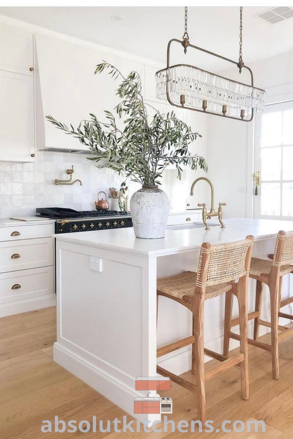 A spacious kitchen with painted white cabinets, an island with chairs, and a potted plant on the counter, showcasing stylish kitchen renovation inspiration and cozy aesthetic decor ideas for small spaces. Discover more designs at absolutkitchens.com.
