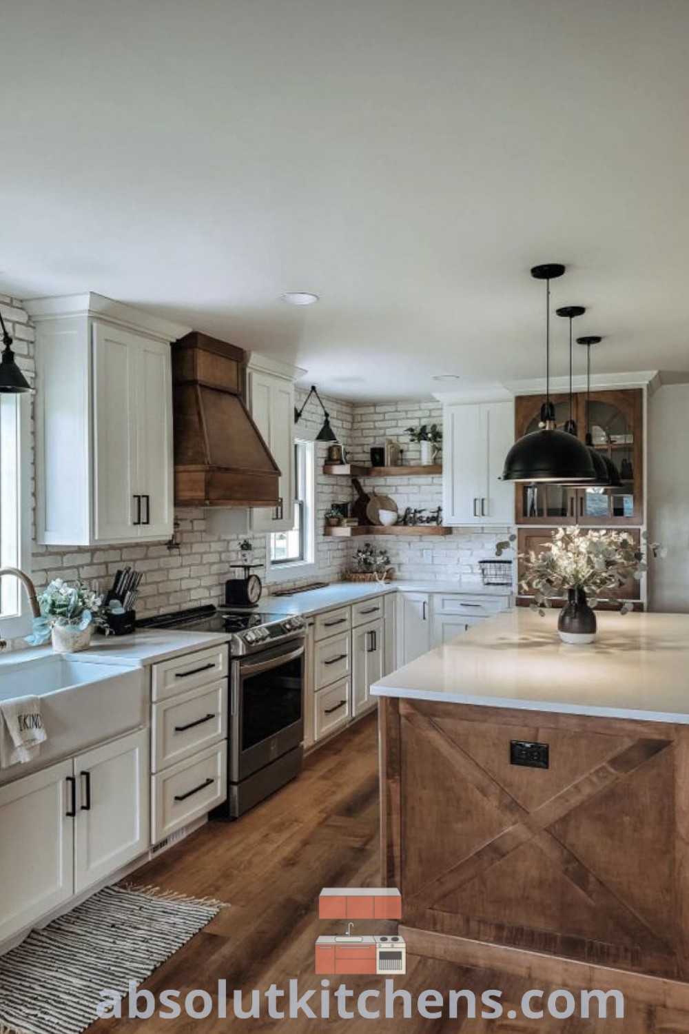 A large modern farmhouse kitchen featuring white cabinets, wood flooring, and a wood island with a white countertop. This space exemplifies inspiring ideas for kitchen design trends, perfect for house or apartment living. Discover more at absolutkitchens.com.
