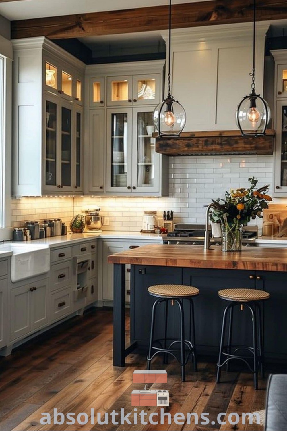 A modern log cabin kitchen featuring wooden floors and gray cabinets, with two stools at the island. This cozy space combines design trends with farmhouse flooring ideas for a warm aesthetic, offering inspiring decor ideas for small spaces. Discover more at absolutkitchens.com.