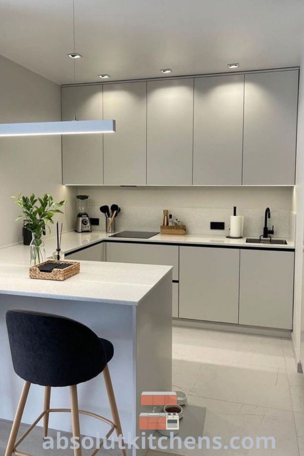 A modern white matt kitchen with two ovens and an empty layout, showcasing a minimal kitchen design and luxury cabinetry. The space is inviting and offers inspiring decor ideas to create a cozy home. Find more unique kitchen design inspirations at wellnesswink.com.