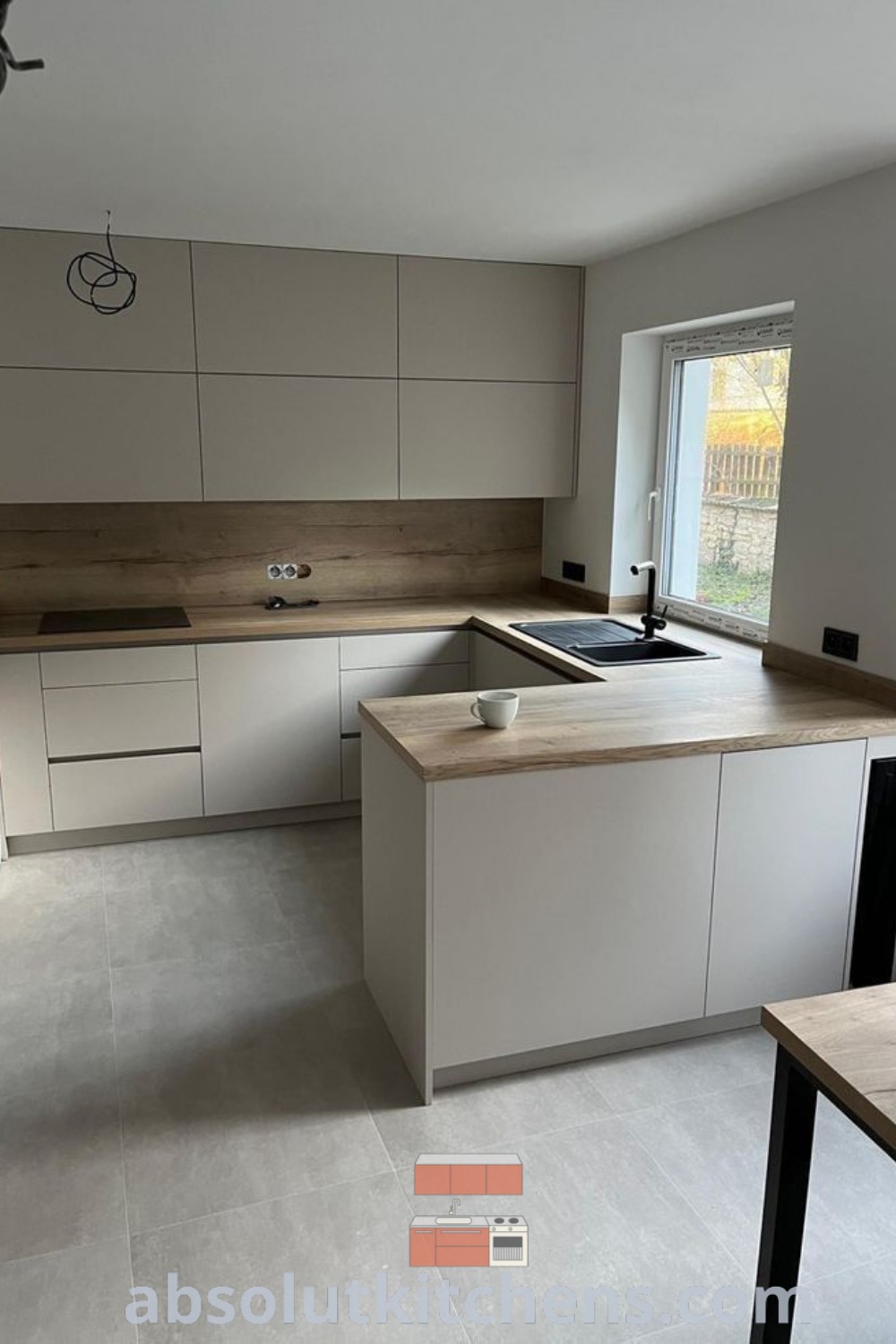 An empty modern white kitchen with sleek cabinets and countertops highlights Scandinavian and luxury kitchen design elements, offering unique ideas for your home. This airy layout promotes a cozy ambiance and functionality, perfect for decor inspirations. Discover more design ideas at wellnesswink.com.