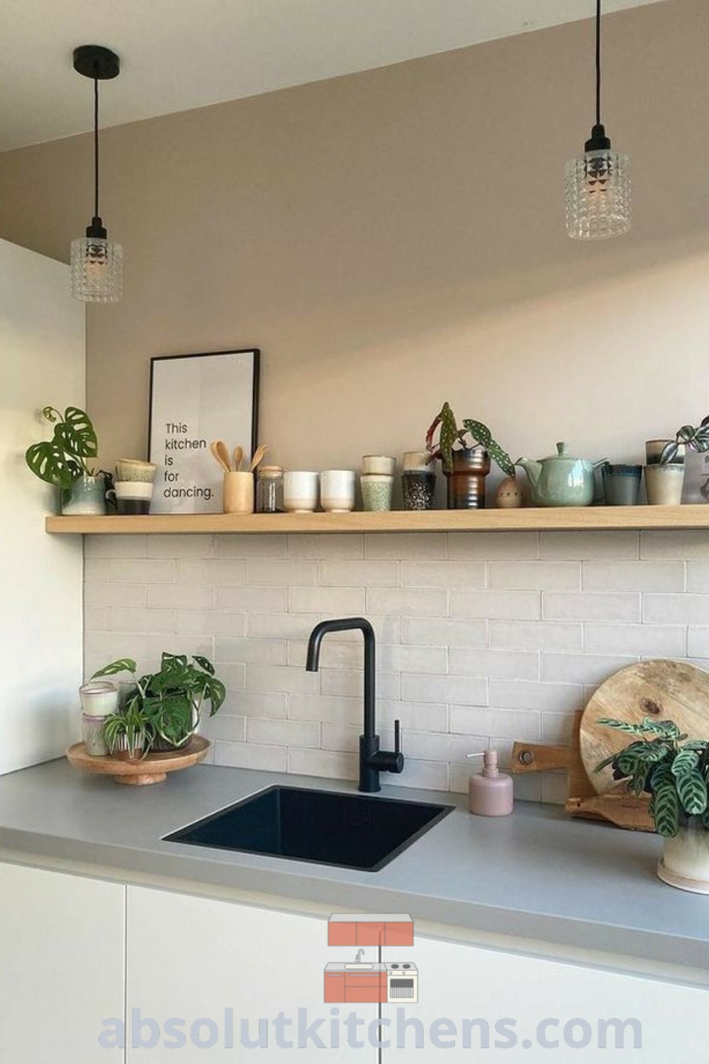 A cozy Scandi style kitchen with white brick walls, shelves above the sink, and potted plants on the counter, offering unique decor ideas for the home. This inviting space inspires kitchen alcove designs and cozy atmospheres, perfect for dancing or gathering. Explore more decor inspirations at wellnesswink.com.