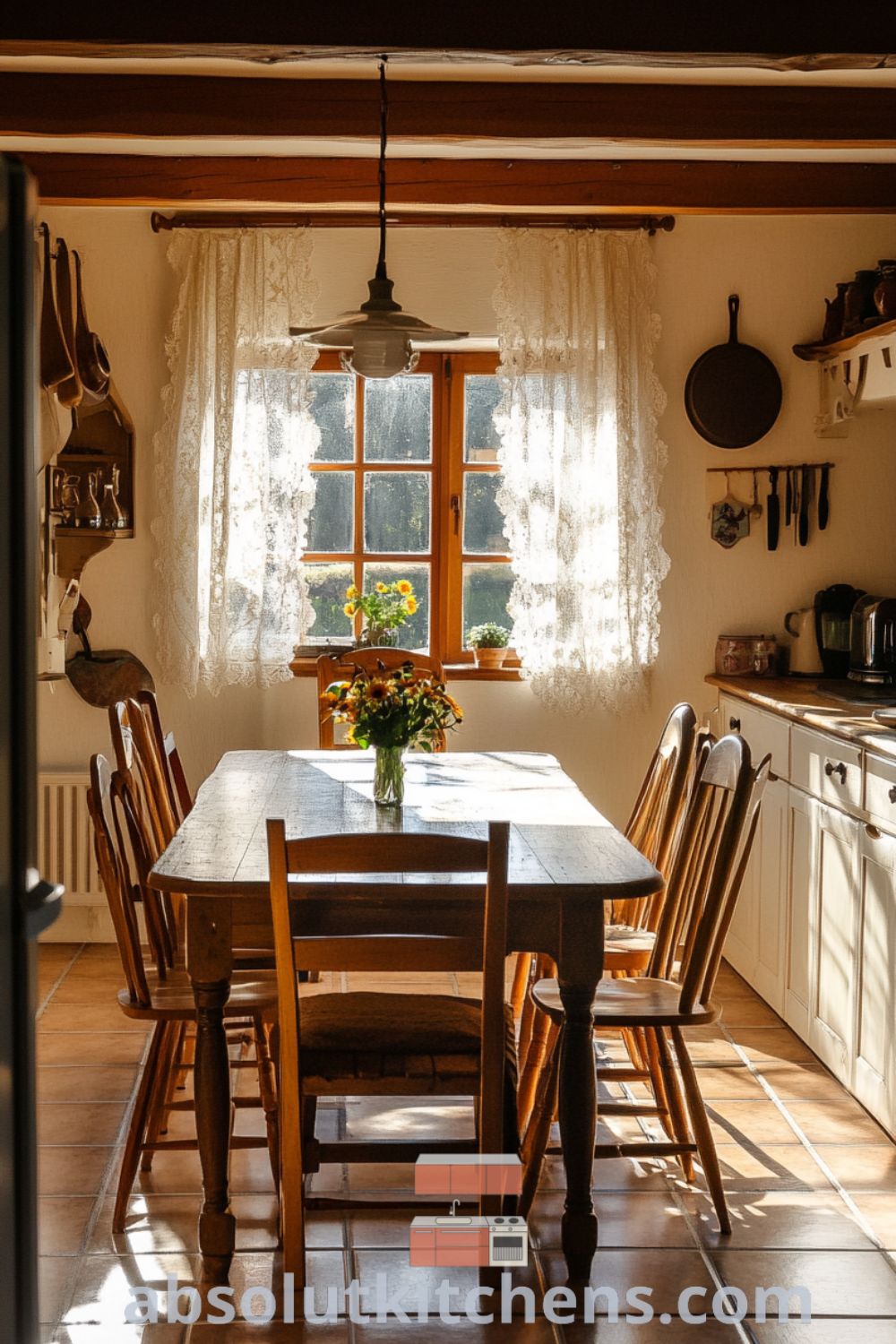 Cozy French kitchen featuring creamy white walls, rustic wooden beams, a large farmhouse table surrounded by mismatched chairs, sunlight streaming through lace curtains, and a bouquet of wildflowers, showcasing decor ideas for a warm and inviting home at absolutkitchens.com.